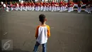 Seorang anak mengamati anggota Paspampres yang melakukan prosesi pergantian jaga Istana Kepresiden di depan Istana Merdeka, Minggu (28/8). Ini merupakan pelaksanaan seremoni pergantian pasukan jaga istana yang kedua kalinya (Liputan6.com/Faizal Fanani)