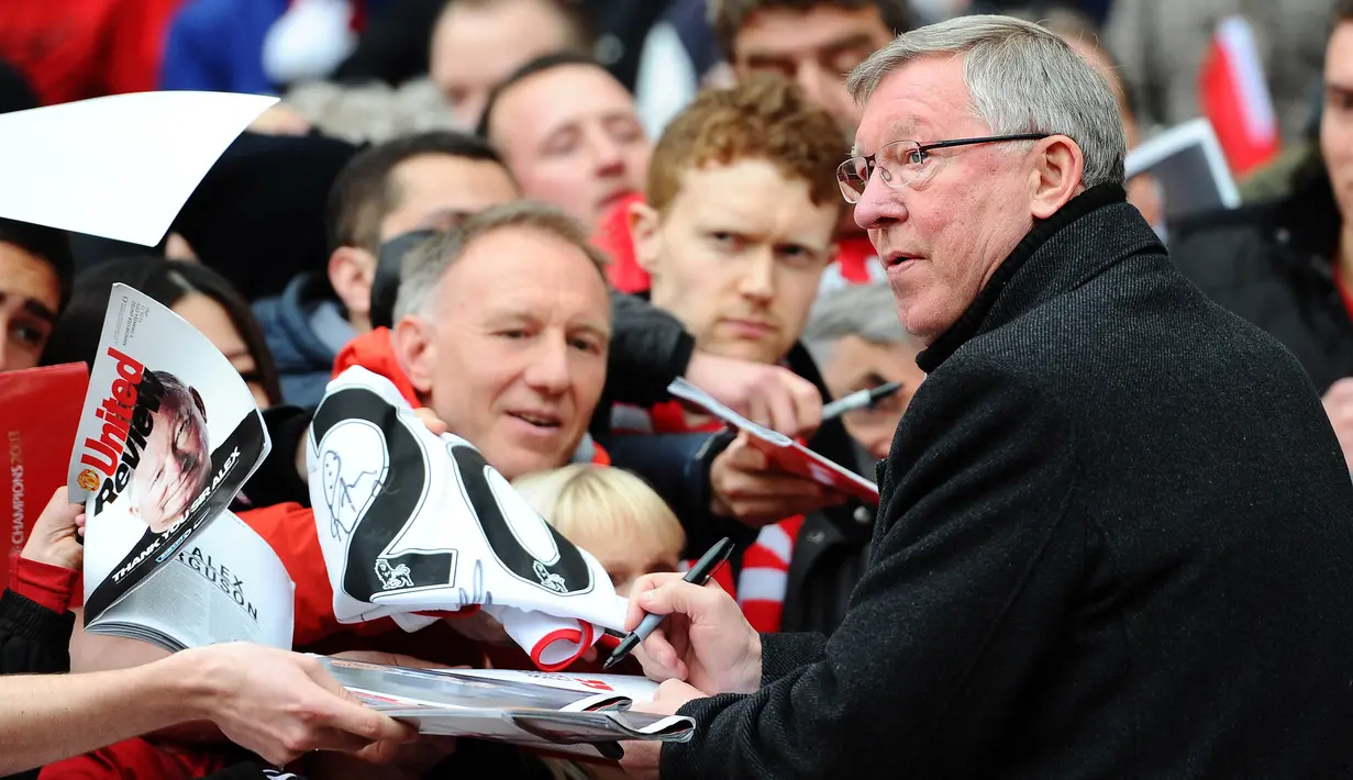 Pelatih Manchester United, Sir Alex Ferguson, memberikan tandan tangan kepada fans saat melawan Swansea City pada laga Premier League di Stadion Old Trafford (12/5/2013). Pertandingan tersebut sekaligus menjadi momen perpisahan Sir Alex Ferguson bersama Setan Merah. (AFP/Andrew Yates)