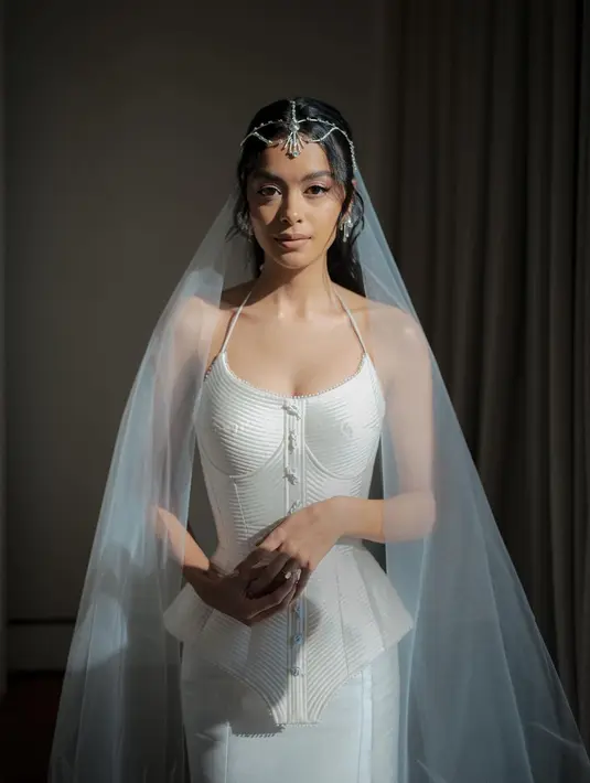 Eva Celia tampil fierce dengan constructed dress yang tegas. Dress dengan detail halterstrap dan siluet korset itu dipadukan dengan satin yang megah [@hiantjen]