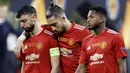 Pemain Manchester United, Bruno Fernandes, Alex Telles dan Fred tertunduk lesu usai ditaklukkan Villarreal pada laga final Liga Europa di Stadion Gdansk, Kamis (27/5/2021). MU gagal menjadi juara usai takluk adu penalti dengan skor 10-11. (AFP/Kackper Pempel/Pool)