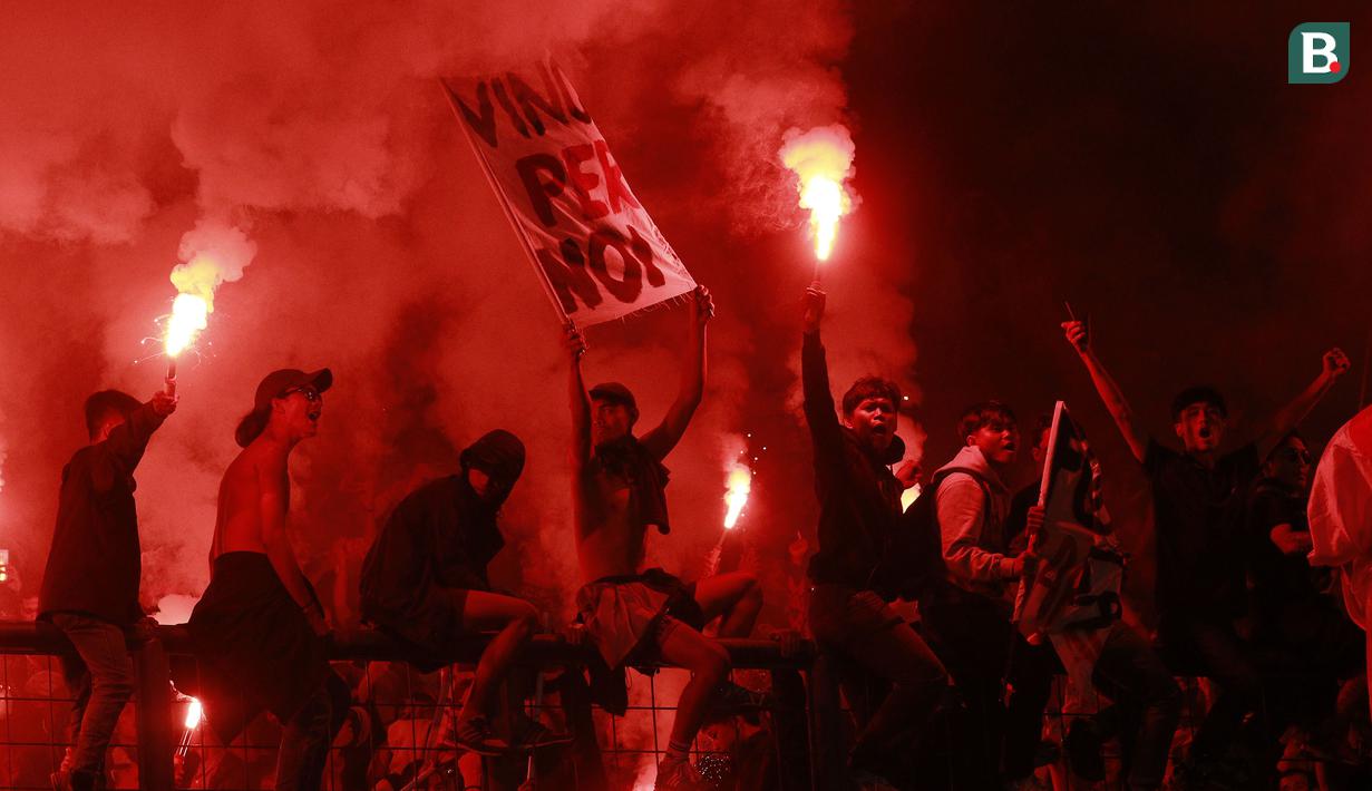 Suporter Timnas Indonesia memberikan dukungan kepada skuat Garuda dengan menyalakan suar saat laga uji coba internasional yang bertajuk FIFA Match Day antara Indonesia melawan Bangladesh di Stadion Si Jalak Harupat, Bandung, Rabu (01/06/2022). Pertandingan berakhir dengan skor kacamata. (Bola.com/M Iqbal Ichsan)