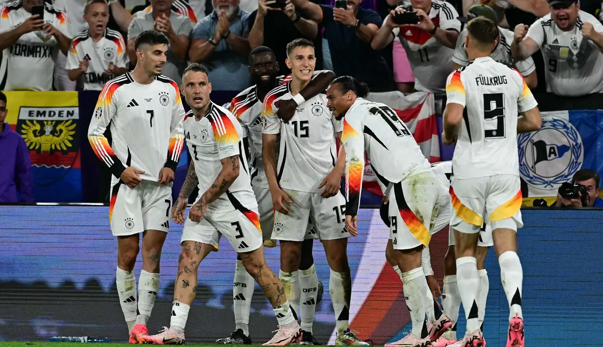 Gelandang Jerman, Jamal Musiala merayakan golnya bersama rekan-rekannya saat pertandingan babak 16 besar Euro 2024 melawan Denmark di BVB Stadion Dortmund, Dortmund pada 29 Juni 2024 atau Minggu 30 Juni 2024 dini hari WIB. (Tobias SCHWARZ/AFP)