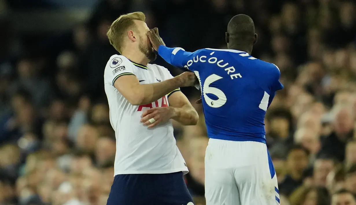 Bentrokan pun tak terhindarkan, Kane langsung merespons dengan menarik baju dan dengan refleks Doucoure mendorong tubuh Harry Kane, nahas tangannya terlebih dulu mengenai muka. (AP Photo/Jon Super)