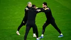 Penyerang Borussia Dortmund #11 Marco Reus (Kiri) dan #21 Donyell Malen (kanan) melakukan peregangan selama sesi latihan menjelang pertandingan Liga Champions di Stadion San Siro di Milan, Senin (27/11/2023). (MARCO BERTORELLO / AFP)