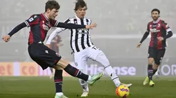 Bek Juventus Luca Pellegrini berebut bola dengan penyerang Bologna Andreas Skov Olsen pada laga pekan ke-18 Liga Italia di Stadio Renato Dall'Ara, Minggu (19/12/2021) dini hari WIB. Bertamu ke markas Bologna, Juventus sukses mengalahkan tuan rumah dengan skor 2-0. (Massimo Paolone/LaPresse via AP)