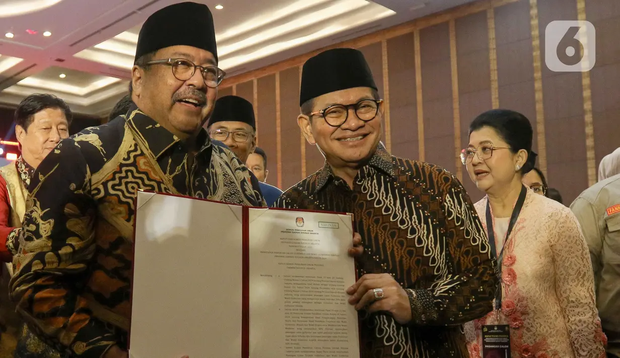 Pasangan Gubernur dan Wakil Gubernur Provinsi Daerah Khusus Jakarta terpilih, Pramono Anung dan Rano Karno menunjukkan surat keputusan Komisi Pemilihan Umum Daerah (KPUD) Jakarta usai menghadiri rapat pleno di Hotel Pullman Central Park, Jakarta, Kamis (9/1/2024). (Liputan6.com/Herman Zakharia)