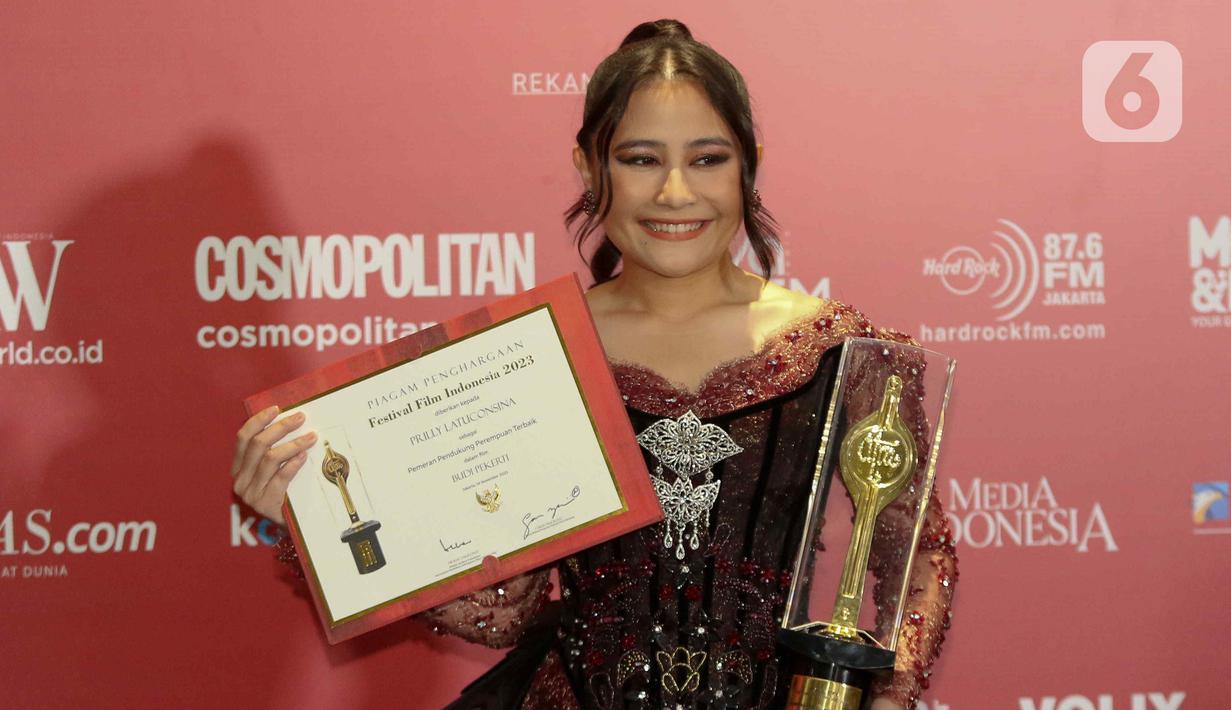 Aktris Prilly Latuconsina berpose memegang piala seusai menerima Anugerah Festival Film Indonesia (FFI) 2023 kategori Pemeran Pendukung Wanita Terbaik di Ciputra Artpreneur, Jakarta, Selasa (14/11/2023). (Liputan6.com/Herman Zakharia)