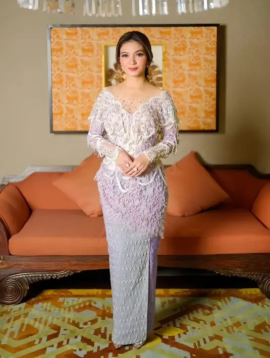 Pesona Selvi Ananda mengenakan kebaya yang telah dimodifikasi modern. Kebaya putih dengan garis leher yang dalam dipadu kain wastra bernuansa serasi. [Foto: Instagram/selvirakabuming]