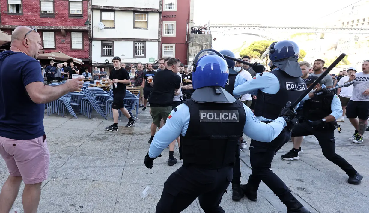 Polisi membubarkan suporter Manchester City yang berkelahi saat minum di tepi sungai Douro di Porto, Portugal (28/5/2021).  Para suporter melanggar jam malam dengan menghabiskan waktu di pub dan bar. (AP Photo/Luis Vieira)