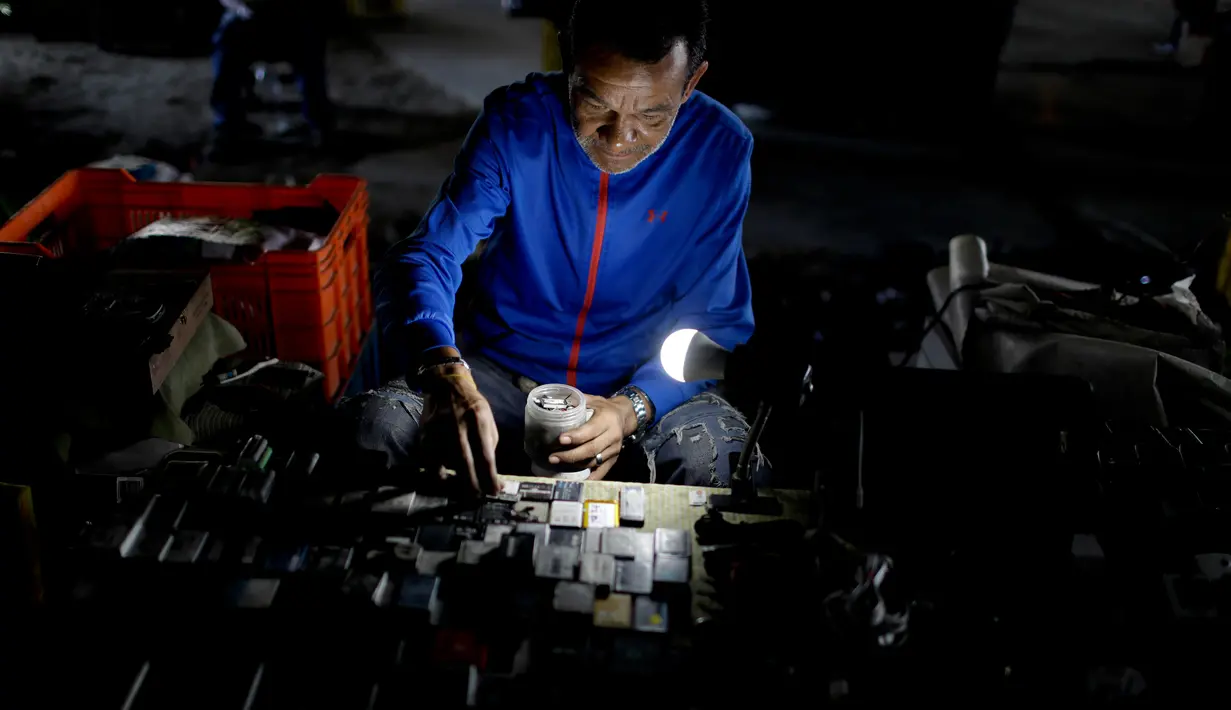 Seorang lelaki menata baterai bekas saat menjajakannya di Caracas, Venezuela, Rabu (20/3). Krisis Venezuela menyebabkan warganya menjual barang-barang bekas untuk mendapatkan uang. (AP Photo/Natacha Pisarenko)