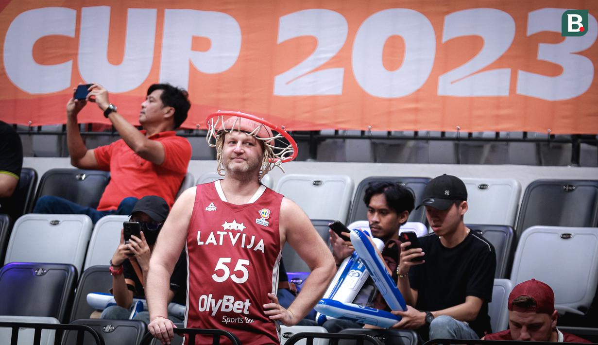 <p>Pendukung Latvia mengenakan topi berbentuk ring basket menjelang laga perdana Grup H Piala Dunia FIBA 2023 antara Timnas Basket Latvia melawan Timnas Basket Lebanon di Indonesia Arena, Senayan, Jakarta, Jumat (25/08/2023). Lebanon menang dengan skor 109-70. (Bola.com/Bagaskara Lazuardi)</p>