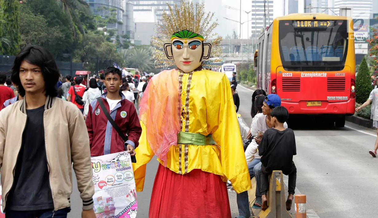 Pengamen ondel-ondel meminta sumbangan kepada warga di lokasi car free day, Jakarta, Minggu (21/5). Seiring berjalannya waktu, ondel-ondel kini dimanfaatkan oleh warga Jakarta untuk mencari nafkah. (Liputan6.com/Immanuel Antonius)
