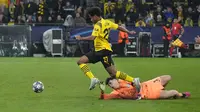 Pemain Borussia Dortmund, Karim Adeyemi berhasil melewati kiper Chelsea, Kepa Arrizabalaga untuk mencetak gol dalam laga leg pertama babak 16 besar Liga Champions 2022/2023 di Signal Iduna Park, Dortmund, Kamis (16/2/2023) dini hari WIB. (AP Photo/Martin Meissner)