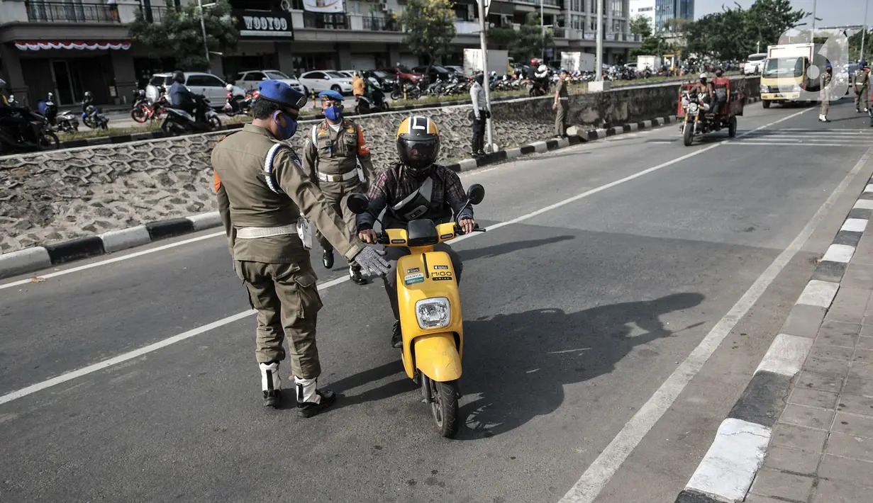 Petugas gabungan memberhentikan pengendara motor yang tidak mengenakan masker di kawasan Sunter, Jakarta, (3/9/2020). Dari total sanksi denda PSBB transisi di Jakarta yang mencapai Rp4 Miliar, Rp2,1 Miliar diantaranya merupakan denda pelanggar tidak menggunakan masker. (merdeka.com/Iqbal Nugroho)
