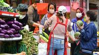 Pembeli membeli sayuran sehari setelah banyak toko kehabisan beberapa produk di Hong Hong ketika pembatasan Covid-19 yang lebih ketat mulai berlaku menyusul jumlah infeksi tertinggi di kota itu sejak pandemi dimulai, Rabu (9/2/2022). (Peter PARKS / AFP)