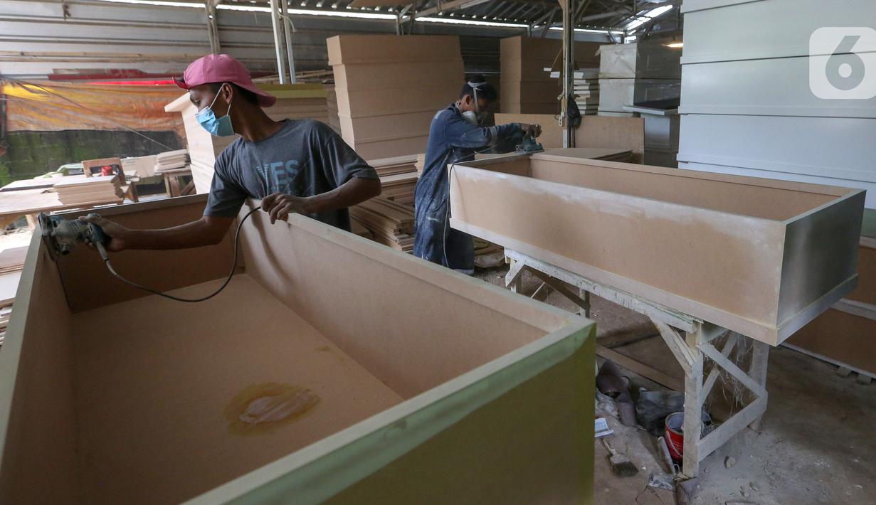 Pekerja menyelesaikan pembuatan peti mati Covid-19 di Rawa Mekar Jaya, Serpong, Tangerang Selatan, Kamis (21/01/2021). Produksi peti mati berbahan baku papan MDF meningkat cukup tinggi sejak bulan November 2020. (Liputan6.com/Fery Pradolo)