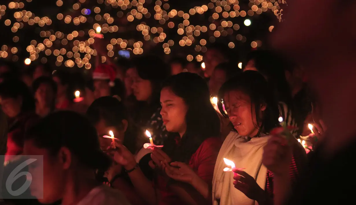 Sejumlah umat Kristiani sampak khusyuk saat perayaan Natal Gereja Tiberias di GBK, Jakarat, (5/12).Ribuan Umat menyalakan lililn bersama sambil berdoa. (Liputan6.com/Angga Yuniar)
