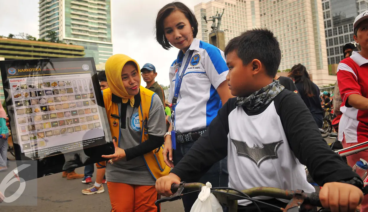 Seorang petugas BNNP memberikan penjelasan tentang narkoba kepada seorang anak di CFD, Jakarta, Minggu (5/2). Soasialisi tersebut dilakukan untuk memberikan pengetahuan kepada masyarakat jenis narkoba dan bahaya narkoba. (Liputan6.com/Angga Yuniar)