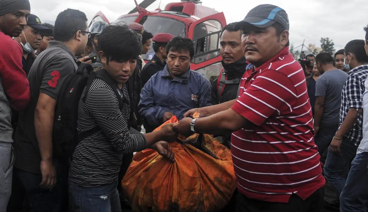 Petugas mengevakuasi korban tewas untuk dibawa ke rumah sakit, di sebelah utara Ibu Kota Nepal, Kathmandu, Senin (8/8). Tujuh orang, termasuk bayi dan pilot tewas akibat jatuhnya Helikopter Fishtail Air. (AFP PHOTO/BIKASH Karki)