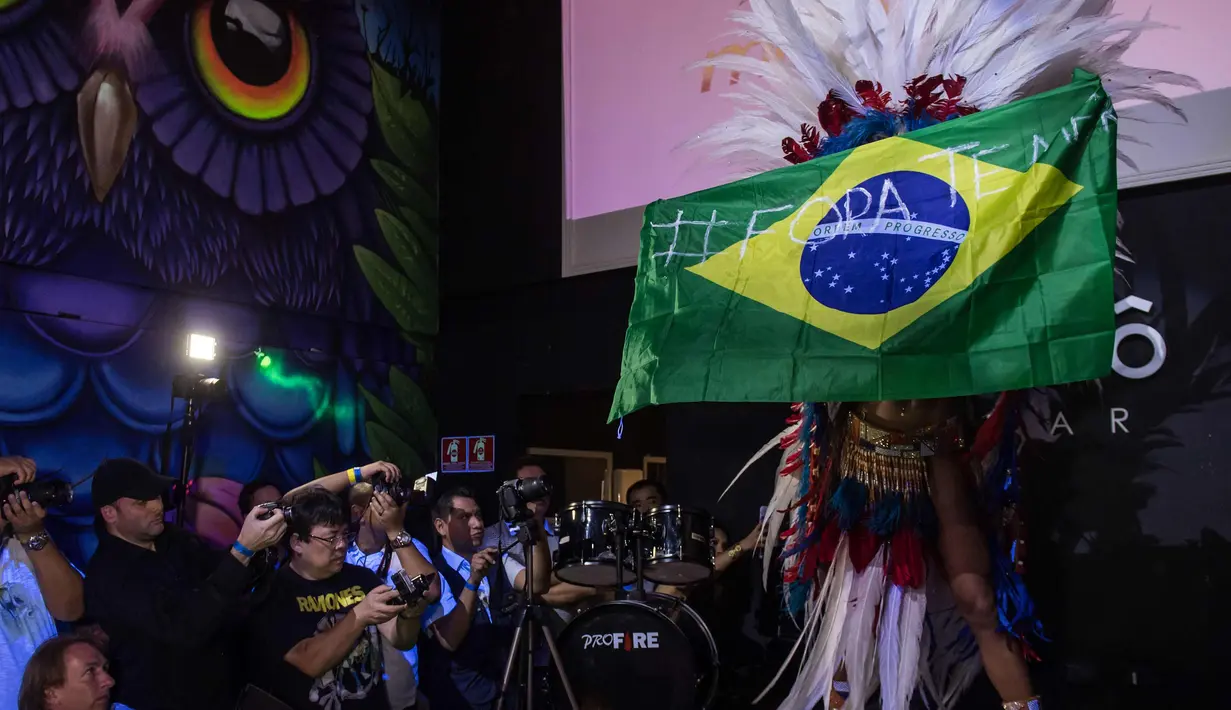 Rosie Oliveira dari Amazonas memegang bendera nasional Brasil dengan tulisan "Temer out" (referensi untuk Presiden Brasil Michel Temer) selama kontes Miss Bumbum Brazil 2017 di Sao Paulo (7/11). (AFP PHOTO/Nelson Almeida)