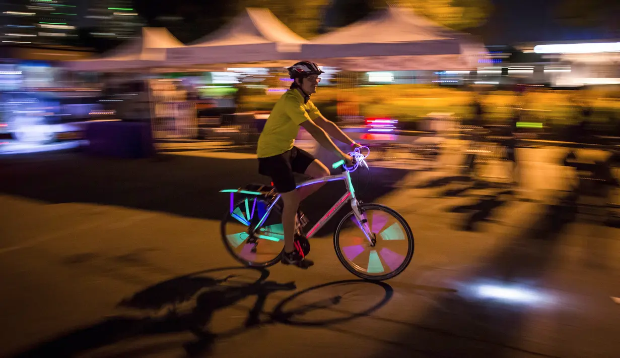 Seorang peserta mengendarai sepedanya dengan hiasan lampu saat berpartisipasi dalam acara Bike the Night di Vancouver, BC, (16/9). Para peserta berkeliling di sekitar False Creek dan pusat kota pada rute 10 km. (Darryl Dyck/Canadian Press via AP)