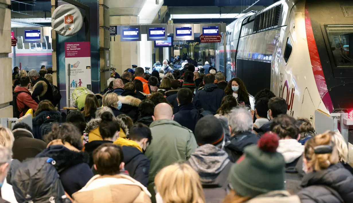 Warga Paris berjalan di sepanjang peron untuk naik kereta yang berangkat dari Gare Montparnasse di Paris, Jumat (19/3/2021). Warga Paris memadati kereta antar kota yang berangkat dari ibu kota beberapa jam sebelum lockdown selama sebulan untuk memerangi lonjakan infeksi COVID-19. (Ludovic MARIN/AFP)