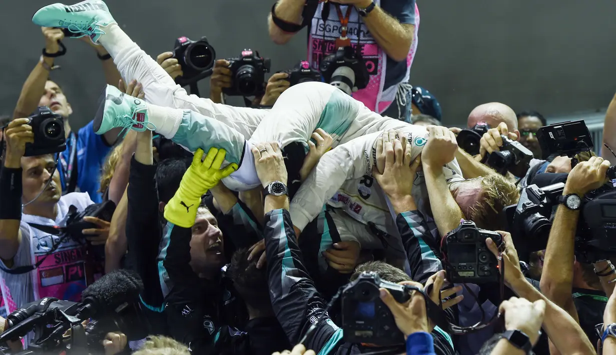 Nico Rosberg merayakan keberhasillanya menjuarai F1 Singapura bersama timnya  Mercedes AMG Petronas F1 di Singapore, (18/9/2016). (AFP/Anthony Wallace)