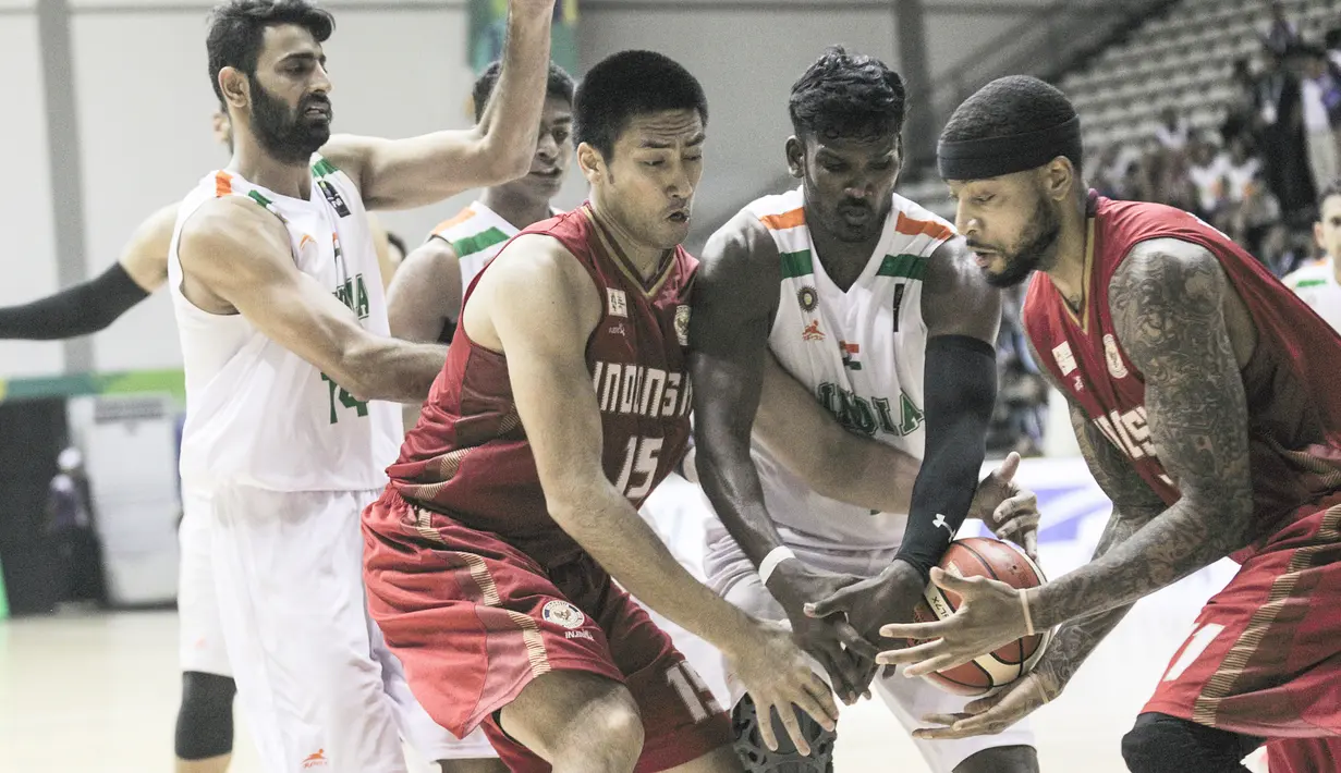 Pebasket Indonesia, Christian Sitepu dan Jamarr Johnson merebut bola dari pemain India pada final Invitation Tournament Asian Games 2018 di GBK Hall Basket, Jakarta. Indonesia menang 78-68 atas India. (Bola.com/Peksi Cahyo)