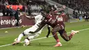 Penyerang Metz, Ibrahima Niane berebut bola dengan bek Paris Saint-Germain (PSG), Nuno Mendes pada laga pekan ketujuh Ligue 1 di Stadion Saint-Symphorien, Kamis (23/9/2021) dini hari WIB. PSG menang atas Metz dengan skor tipis 2-1 lewat gol telat Achraf Hakimi. (Jean-Christophe VERHAEGEN/AFP)