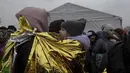 Seorang perempuan menggendong anak yang terbungkus selimut termal setelah melarikan diri dari Ukraina dan tiba di perbatasan di Medyka, Polandia, Senin (7/3/2022). Hampir 2 juta orang melarikan diri dari Ukraina sejak invasi Rusia dengan jumlah itu meningkat setiap hari. (AP Photo/Visar Kryeziu)