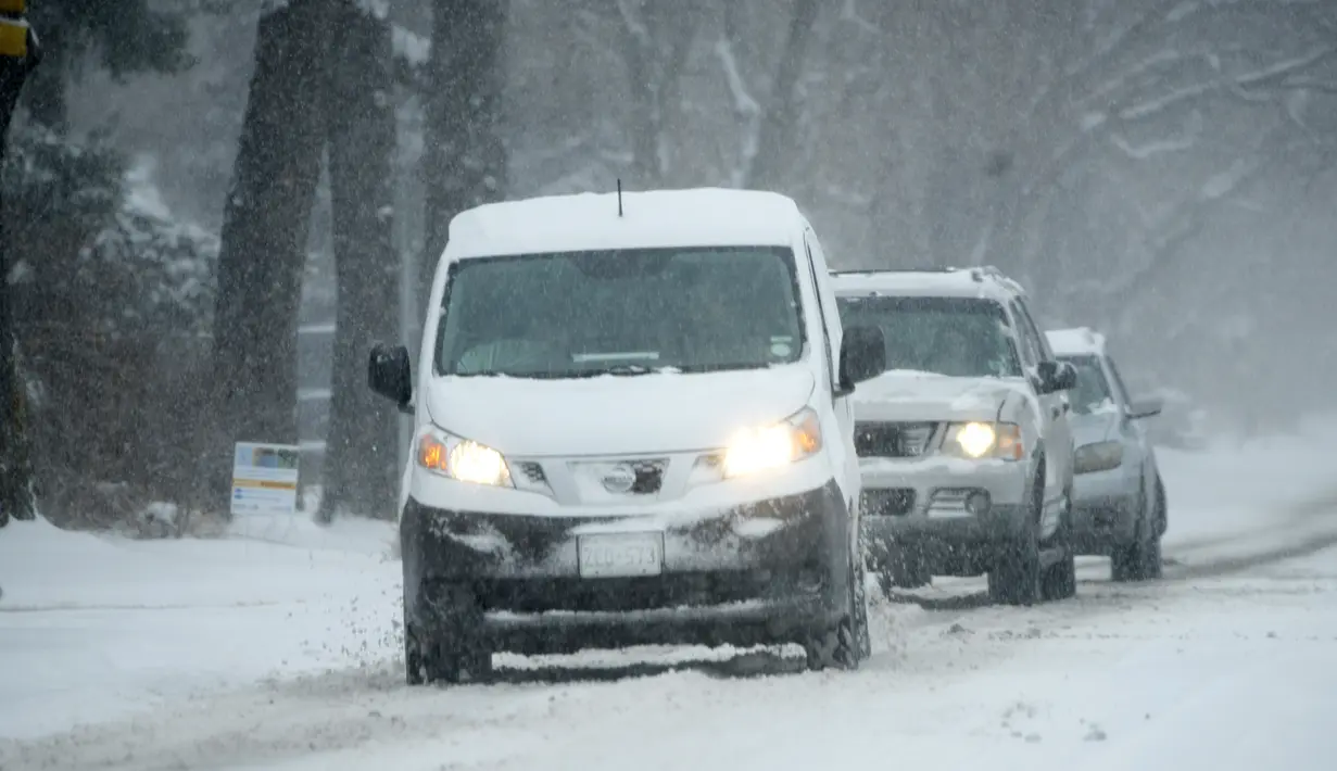 Pengemudi berjuang untuk mempertahankan traksi saat melakukan perjalanan ke timur di sepanjang Buchtel Boulevard saat badai musim dingin menjatuhkan beberapa inci salju di Denver (25/1/2022). (AP Photo/David Zalubowski)