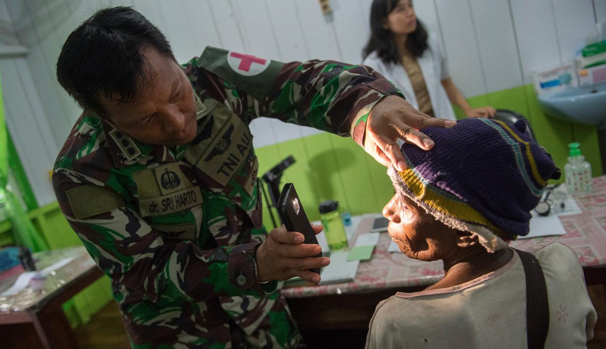 Tim medis dari satuan tugas militer Indonesia memeriksa seorang pasien di rumah sakit setempat di Agats, Asmat, provinsi Papua Barat (26/1). (AFP/Bay Ismoyo)