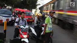 Kereta api melintas di kawasan Lenteng Agung, Jakarta, Kamis (14/3). Pembangunan jalan layang (fly over) berbentuk tapal kuda di perlintasan kereta tersebut diprediksi akan mengurangi tingkat kemacetan antara 40-50 persen. (Liputan6.com/Immanuel Antonius)