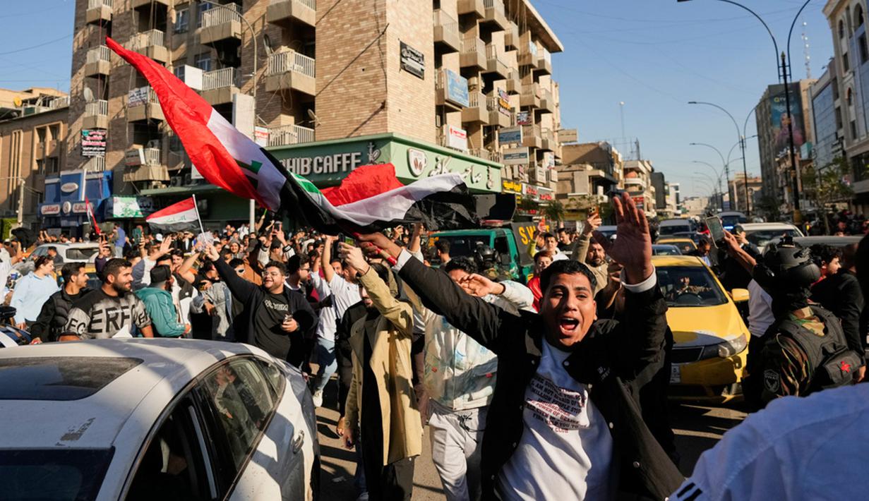 Euforia langsung terasa di ibu kota Baghdad, di mana ribuan warga memadati jalanan dengan mengibarkan bendera, menyanyikan lagu-lagu kebangsaan, dan merayakan pencapaian bersejarah Timnas kebanggan mereka. (AP Photo/ Hadi Mizban)