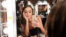 Model berselfie di belakang panggung sebelum tampil mengenakan The Australian Collection Show 2019 selama Miami Swim Week di Miami Beach, Florida (14/7/2019). Miami Swim Week menampilkan pakaian renang yang berlangsung 11 - 16 Juli 2019. (AFP Photo/Jason Koerner)