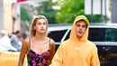 Kalau yang ini, Hailey Baldwin nampak cantik dengan dress bunga-bunga yang menggambarkan musim panas. Sementara Justin memakai hoodie orange dan celana biru. (James Devaney/GC Images/USWeekly)