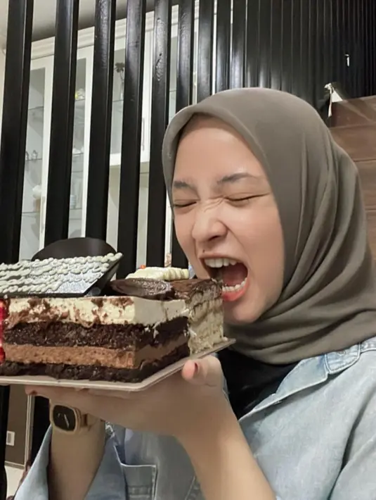 Sedangkan foto ketiga, wanita yang beberapa tahun lalu disebut-sebut sebagai orang ketiga terkait konflik rumah tangga Ayus Sabyan dan Ririe Fairuz memegang kue ulang tahun. Nissa berpose seakan akan menggigit kue ulang tahun. [Instagram/nissa_sabyan]