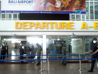 Para pekerja menjaga gerbang keberangkatan saat gladi resik pembukaan kembali Bandara Internasional Ngurah Rai di Bali, Sabtu (9/10/2021). Indonesia berencana kembali membuka Bandara Internasional Ngurah Rai untuk penerbangan internasional pada 14 Oktober 2021. (AP Photo/Firdia Lisnawati)