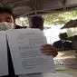Salah seorang pengusaha menunjukkan bukti administratif terkait kekurangan pembayaran suplai kacang tanah dan hijau untuk tambahan makanan nakes. Foto (Liputan6.com / Panji Prayitno)