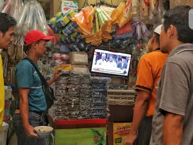 Sejumlah pedagang pasar nonton bareng debat perdana calon presiden Pemilihan Presiden (Pilpres) 2024 yang diselenggarakan oleh Komisi Pemilihan Umum (KPU) di Pasar Kebayoran Lama, Jakarta, Selasa (12/12/2023). (Liputan6.com/Angga Yuniar)