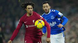 Pemain Liverpool, Trent Alexander-Arnold, berebut bola dengan pemain Everton, Dwight McNeil, pada laga Liga Inggris di Stadion Anfield, Selasa (14/2/2023). Bermain di kandang sendiri, The Reds memenangi derbi Merseyside dengan skor 2-0. (AP Photo/Jon Super)