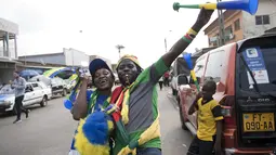 Pedagang Merchandise beraksi saat di foto sedang berjualan di jalanan kota Port-Gentil (18/1/2017). Pemandangan ini menjadi bagian dari penyeleggaraan Piala Afrika 2017. (AFP/Justin Tallis)