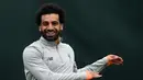 Penyerang Liverpool asal Mesir Mohamed Salah tersenyum saat melakukan pemanasan di kompleks pelatihan Melwood tim di Liverpool, Inggris barat laut, (23/4). Liverpool akan bertanding melawan wakil Italia, AS Roma di stadion Anfield. (AFP Photo/Paul Ellis)