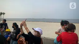 Wisatawan berselfie di Pantai Pasir Putih PIK 2, Tanggerang, Banten, Minggu (3/9/2021). Kawasan Jabodetabek masih berstatus PPKM Level 3 dengan sejumlah pelonggaran di tempat wisata pada akhir pekan yang harus diperhatikan pengunjung dan pengelola. (Liputan6.com/Faizal Fanani)