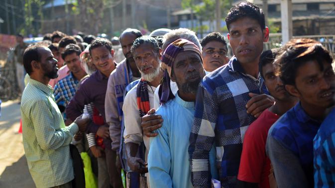 Penduduk Assam di India yang mengantre untuk memeriksakan namanya di National Register of Citizens (NRC), Desa Gumi, Distrik Kamrup. Mereka yang namanya tak tercantum dalam daftar terancam dideportasi (Kulendu Kalita/AP PHOTO via The Guardian)