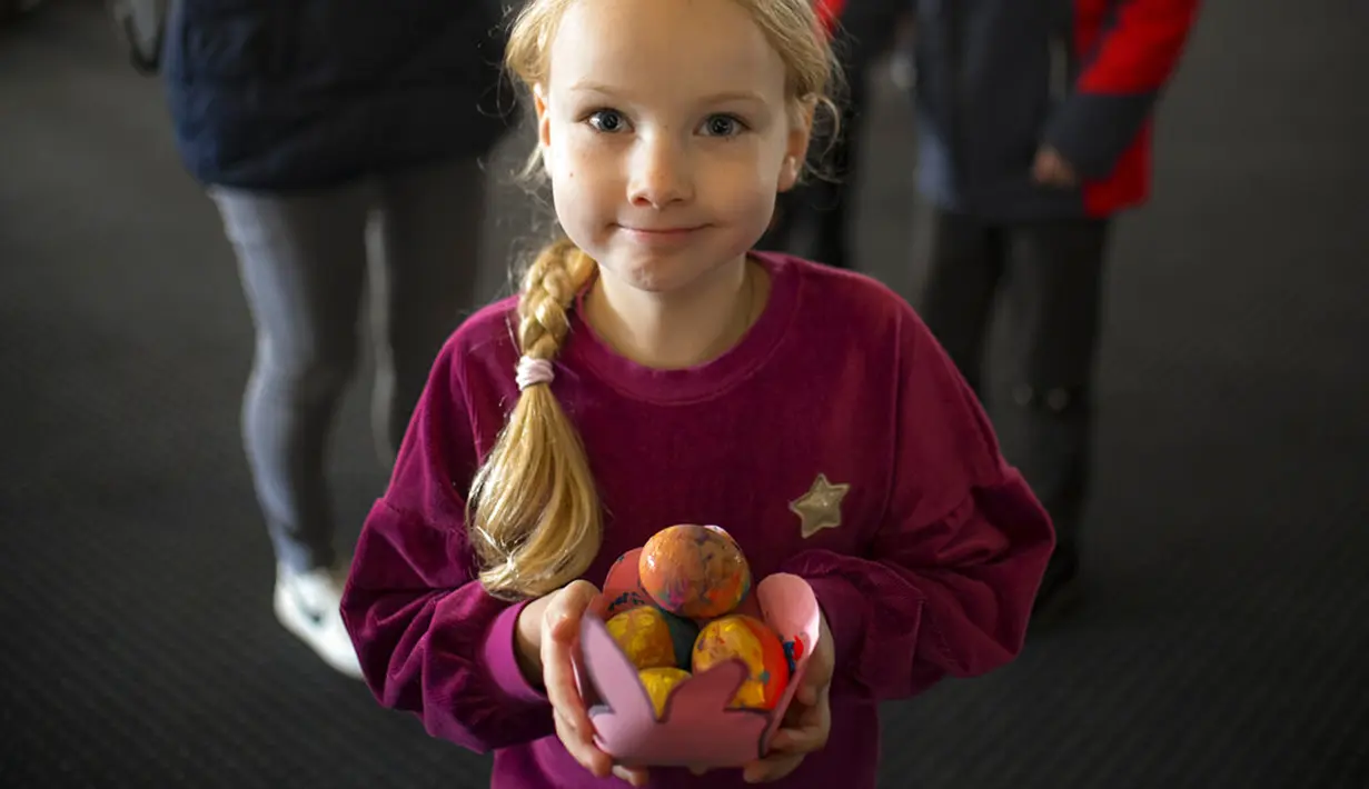<p>Pengungsi anak-anak Ukraina menunjukkan telur Paskah pada Kamis Putih di sebuah pusat pengungsi di Bucharest, Rumania, 21 April 2022. Orang Rumania yang mayoritas jemaat Ortodoks merayakan Minggu Paskah pada 24 April. (AP Photo/Andreea Alexandru)</p>