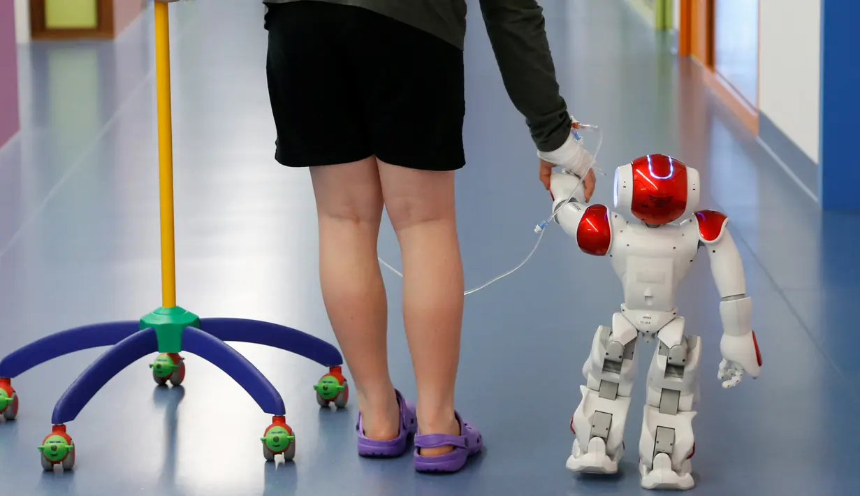Robot humanoid bernama Zora membantu seorang pasien di rumah sakit AZ Damiaan di Ostend, Belgia (16/6). Robot dirancang atau dibuat untuk mengurus pasien yang datang ke rumah sakit ini. (REUTERS / Francois Lenoir)