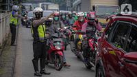 Anggota polisi mengatur lalu lintas saat ganjil genap di kawasan Jalan D.I Panjaitan, Jakarta, Senin (6/6/2022). Perluasan ganjil genap juga sesuai dengan Pergub DKI Jakarta Nomor 88 Tahun 2019. (Liputan6.com/Faizal Fanani)
