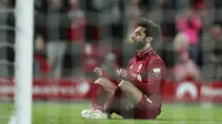 Mohamed Salah duduk di depan gawang usai mencetak gol kelima untuk Liverpool ke gawang Huddersfield Town dalam lanjutan Liga Inggris di Stadion Anfield, Sabtu (27/4/2019) dini hari WIB. (Foto AP / Jon Super)