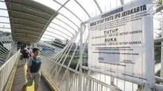 Spanduk besar pengumuman jam buka tutup terpampang di Jembatan Penyeberangan Orang (JPO) Jayakarta di Jakarta, Rabu (25/10). JPO ini menghubungkan Jalan Menteng Tenggulun dan Jalan Sultan Agung. (Liputan6.com/Immanuel Antonius)
